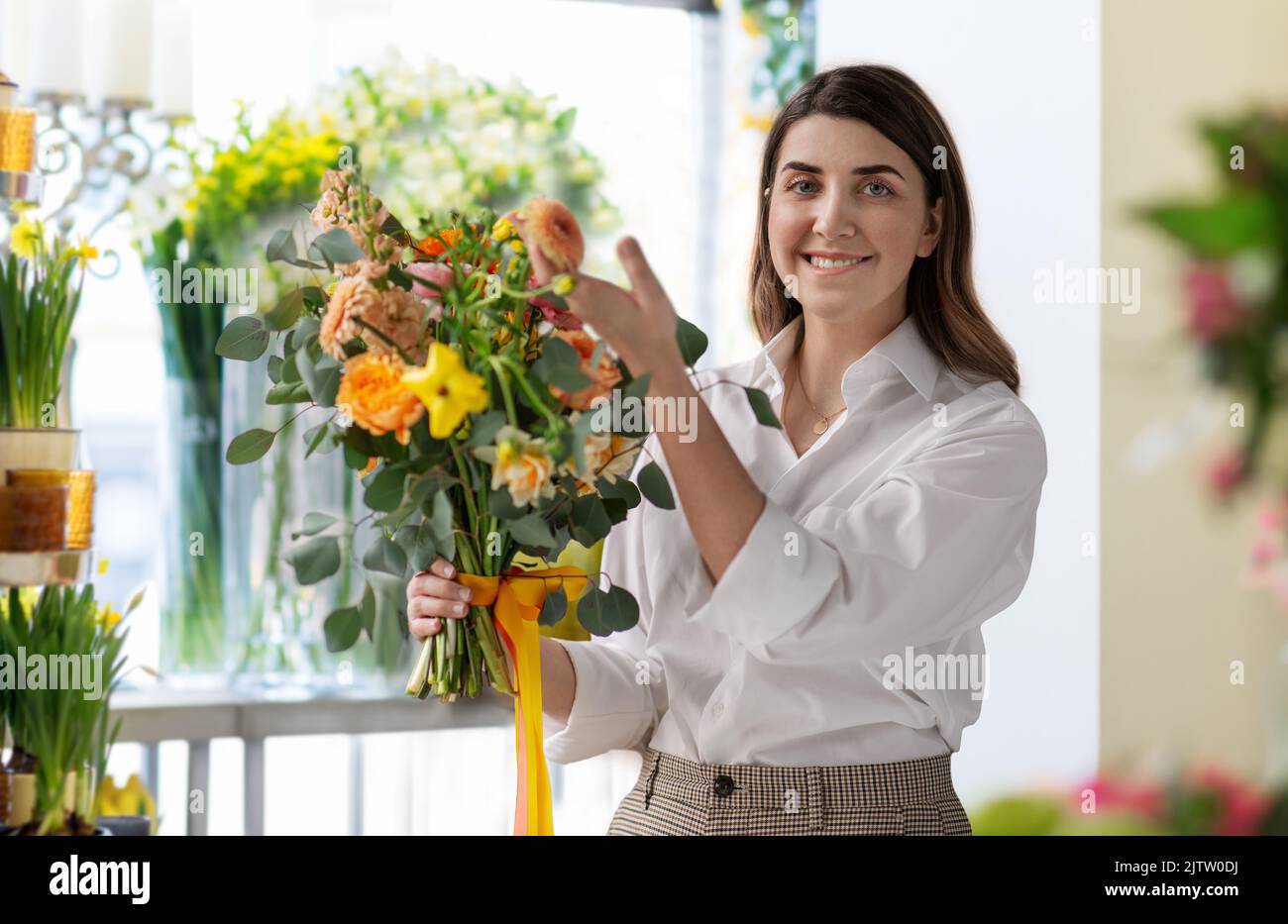 donna felice con mazzo al negozio di fiori Foto Stock