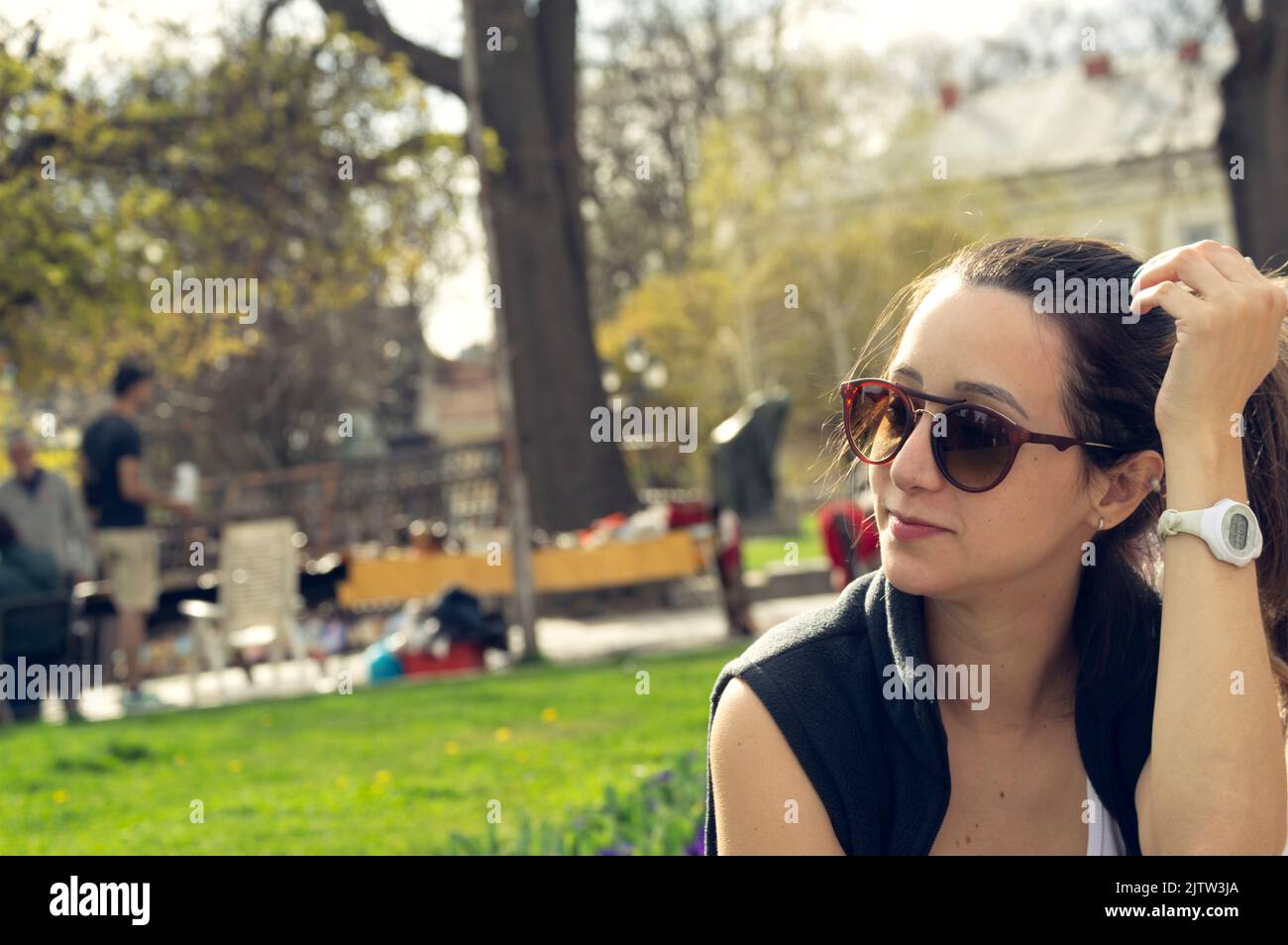 Giovane donna bella in un gilet a piedi su un parco urbano. Stile di vita, autunno, all'aperto Foto Stock