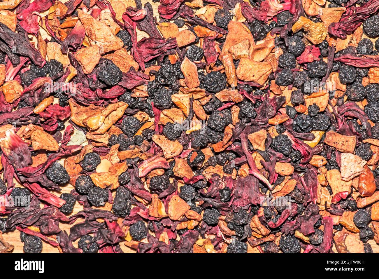 Consistenza di fondo di fragrante tè nero secco con frutta e petali. Tè con predominanza di mirtilli secchi. Sfondo. Foto Stock