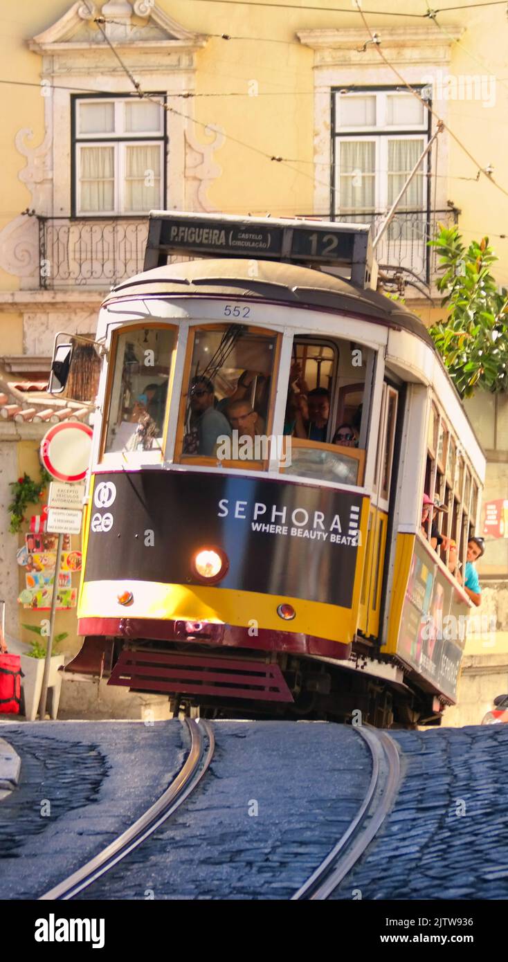 Storico tram 12 che sale su una ripida strada acciottolata fino a Travessa do Acógue, nel quartiere storico di Graa a Lisbona, Portogallo Foto Stock
