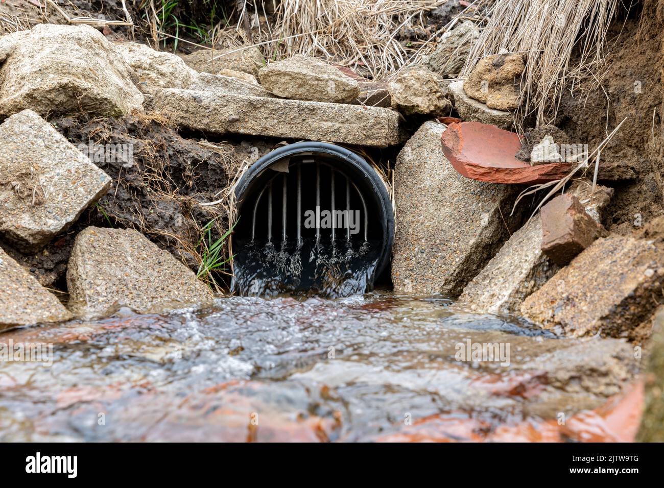 Fattoria campo piastrella sbocco con acqua che scorre. Concetto di drenaggio delle acque, controllo delle inondazioni e agricoltura dell'inquinamento delle acque Foto Stock