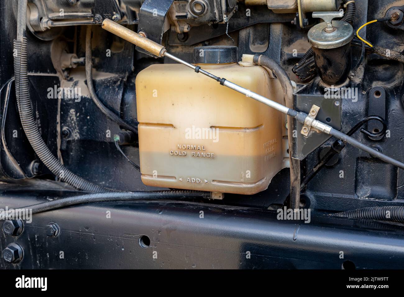 Serbatoio del liquido di raffreddamento antigelo sull'impianto di raffreddamento del trattore agricolo. Concetto di riparazione, manutenzione e assistenza delle attrezzature agricole e agricole Foto Stock