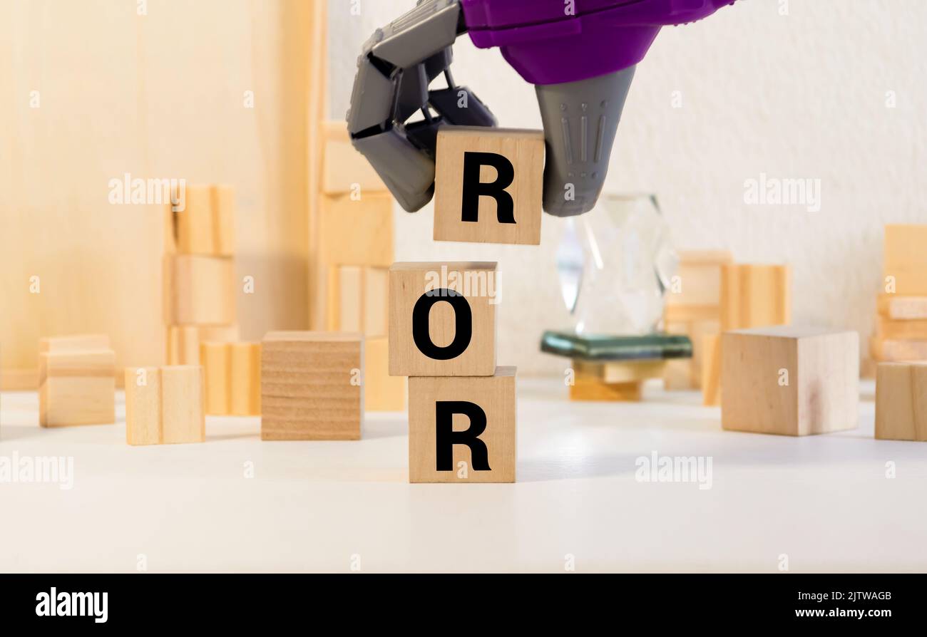 ROR la parola su cubi di legno, cubi in piedi su una superficie riflettente, sullo sfondo è un business diagramma. Concetto di business e finanza. ror - breve Foto Stock