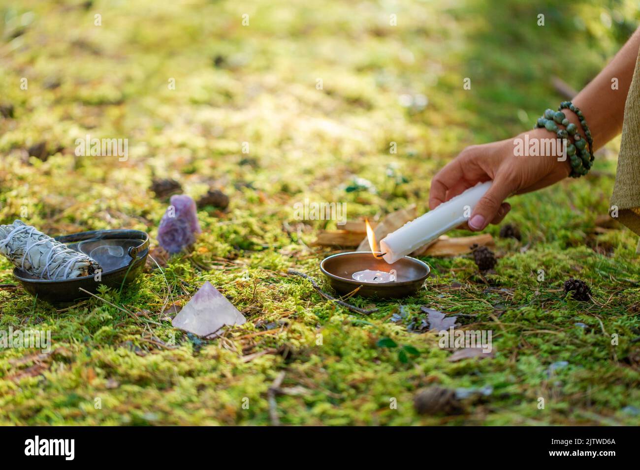 mano con candela esecuzione rituale magico nella foresta Foto Stock