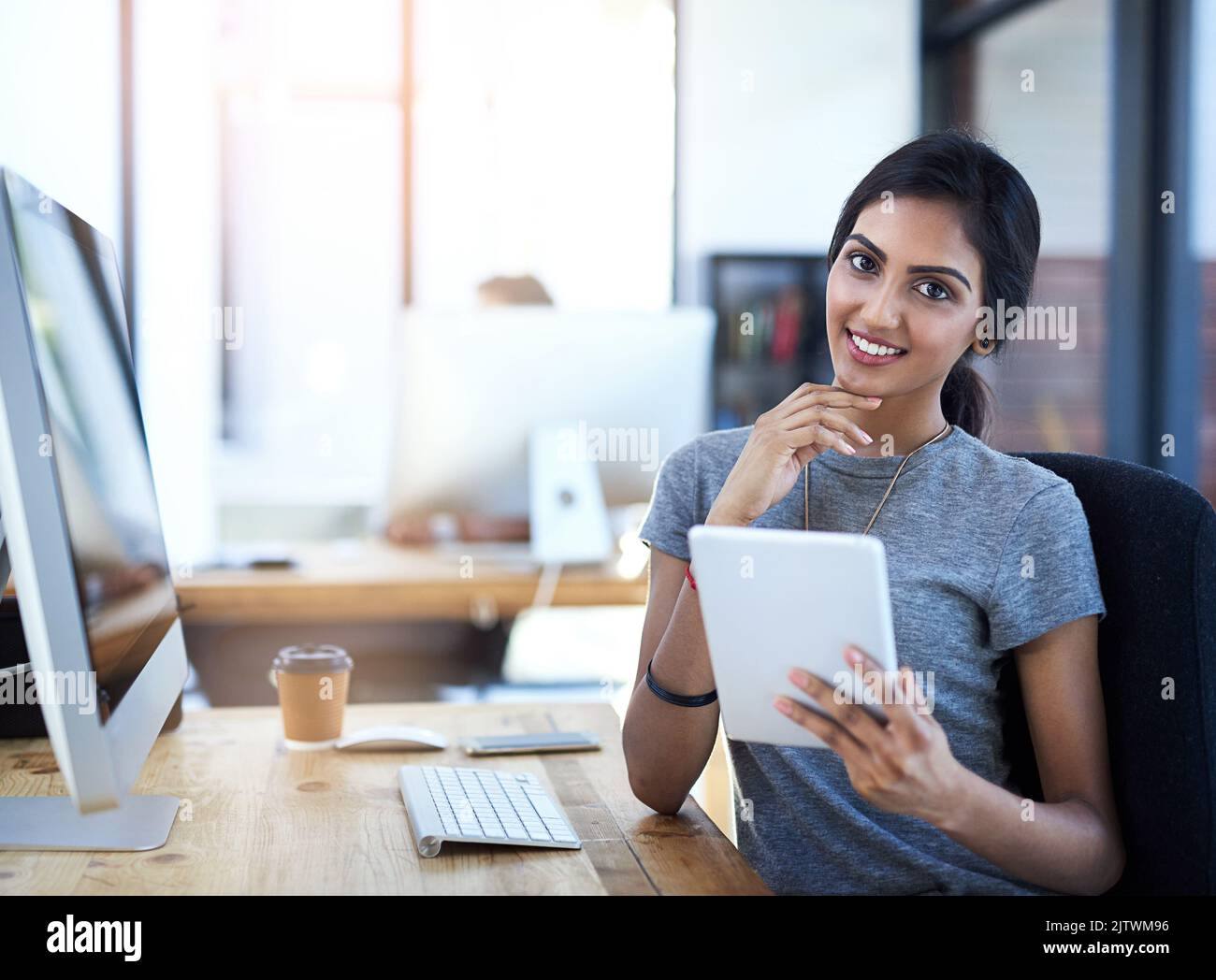 Il tablet è uno dei miei strumenti aziendali preferiti. Ritratto di una giovane donna d'affari che utilizza un tablet digitale alla sua scrivania. Foto Stock