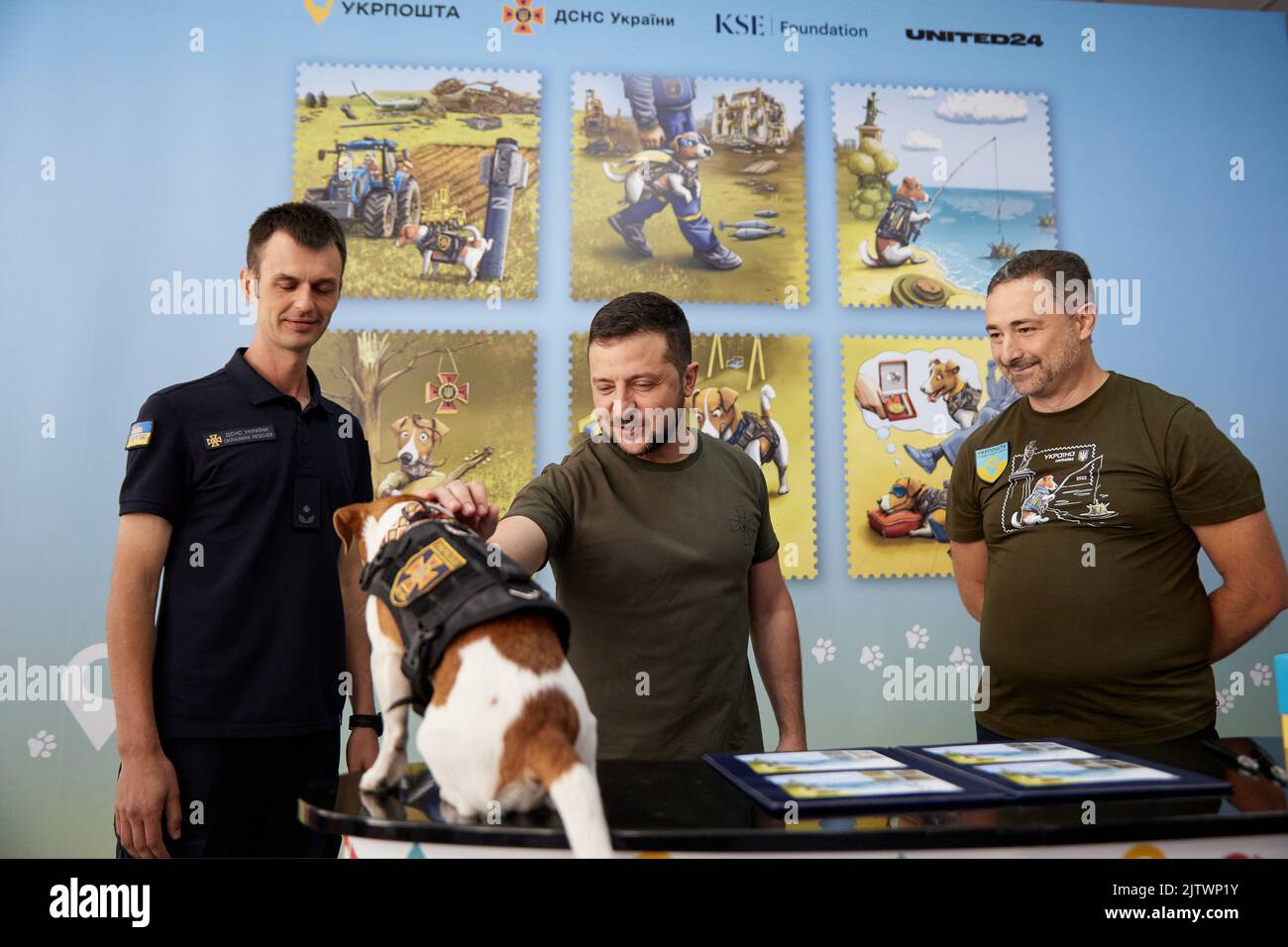 Irpin, Kyiv Blast, Ucraina. 1st Set, 2022. Il presidente ucraino VOLODYMYR ZELENSKY (C) si è Unito al capo del suo ufficio postale IGOR SMELYANSKY (R) per onorare la celebrità canina preferita del paese, 'Patron' il cane che piange i minatori, con la sua serie di francobolli. Il cane è diventato una stella del Internet dopo l'invasione russa dell'Ucraina dopo l'Unione delle squadre di smaltimento della bomba. Zelensky ha visitato una scuola a Irpin, per celebrare il coraggioso Jack Russell terrier. Ora i nuovi francobolli di beneficenza sono dedicati a questo eroe a quattro zampe. I fondi della vendita dei francobolli da parte dell'Ufficio postale saranno utilizzati per l'acquisto di un Armtrac Foto Stock