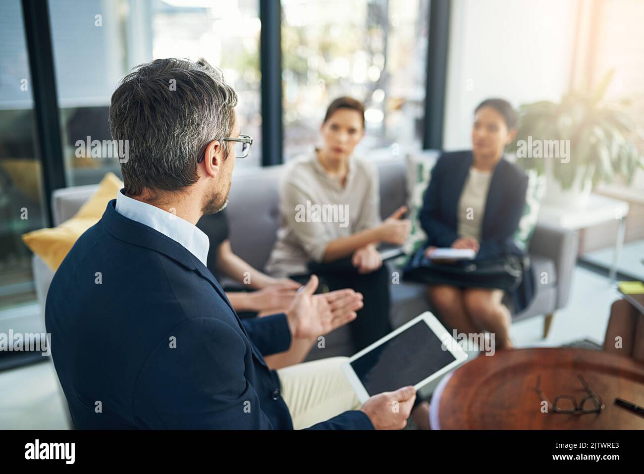 Un gruppo di uomini d'affari che ascoltano il proprio manager durante una riunione. Foto Stock