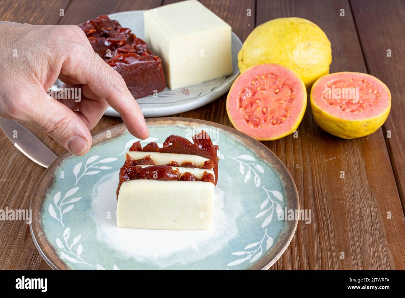 Uomo che raccoglie fette impilate di guava dolce e formaggio cagliato Foto Stock