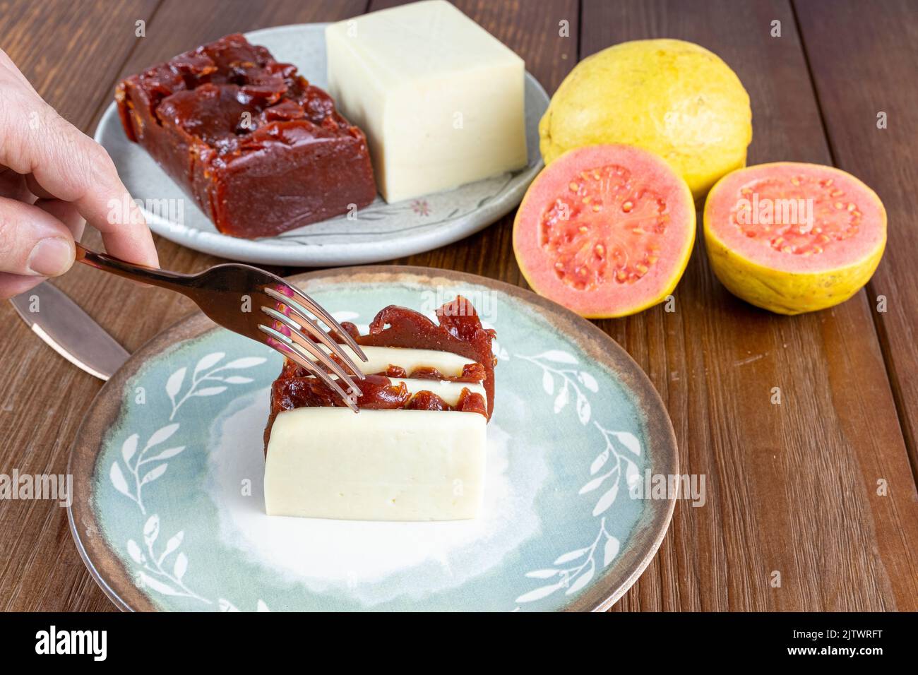 Uomo con forchetta pronto a tagliare fette di guava dolce e riccio. Foto Stock