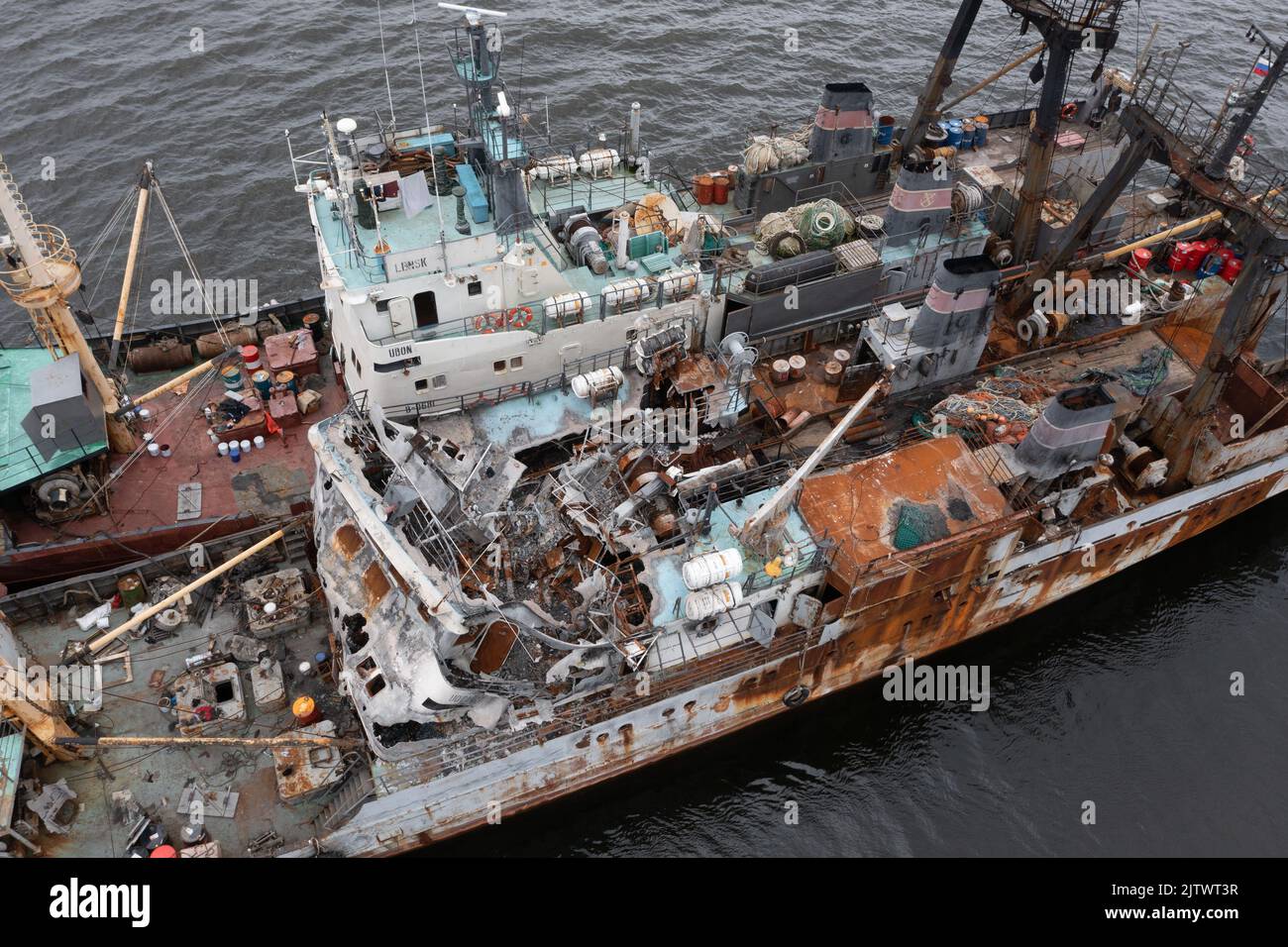 Vladivostok, Russia - 23 luglio 2022: Il peschereccio bruciato su un ormeggio con un'altra nave. Foto Stock