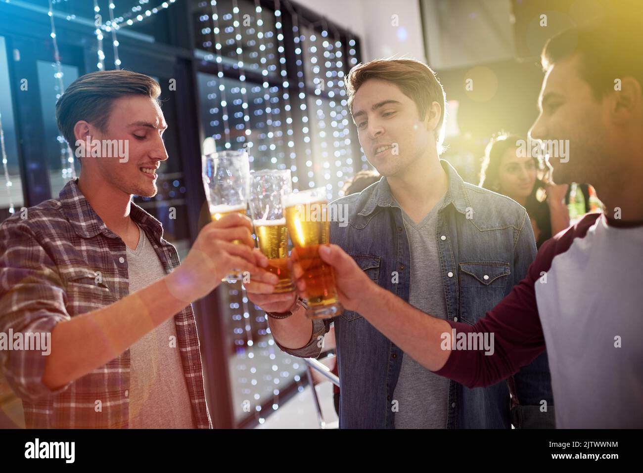 Heres ai ragazzi notte. Ragazzi brinda con le birre ad una festa. Foto Stock