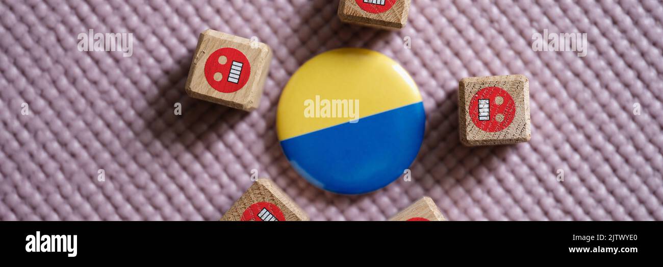 Badge con bandiera di Ucraina che giace tra emoticon male primo piano Foto Stock