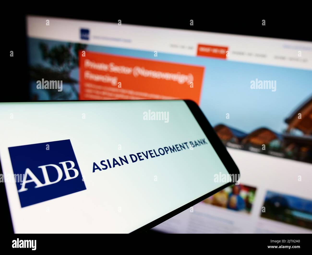 Smartphone con logo dell'organizzazione Asian Development Bank (ADB) sullo schermo davanti al sito Web aziendale. Messa a fuoco al centro a sinistra del display del telefono. Foto Stock
