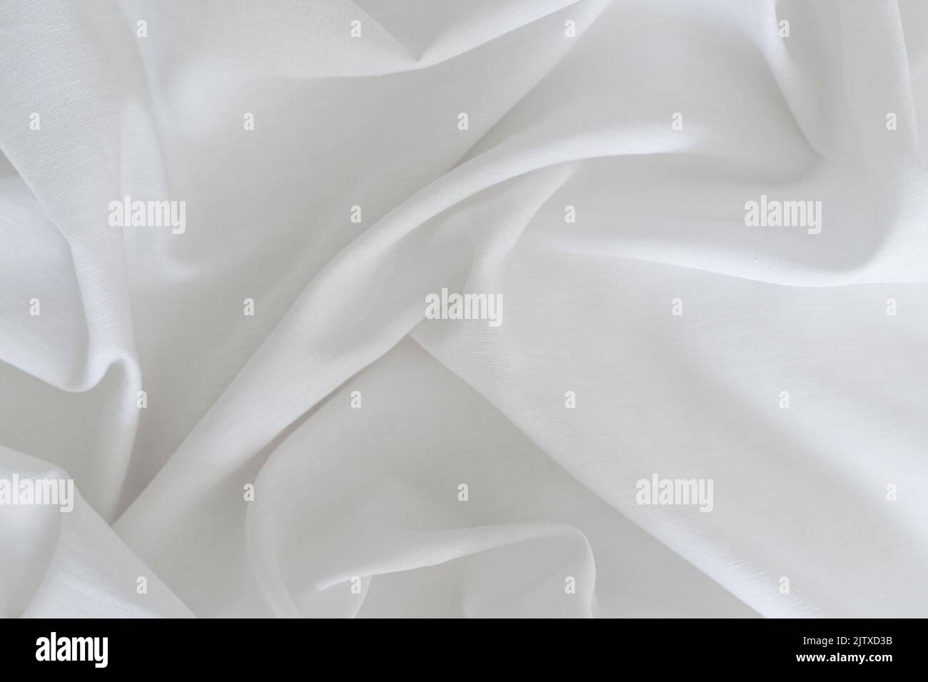 Sfondo bianco tessuto drappeggi. Struttura della superficie leggera del tessuto. Foto di alta qualità Foto Stock