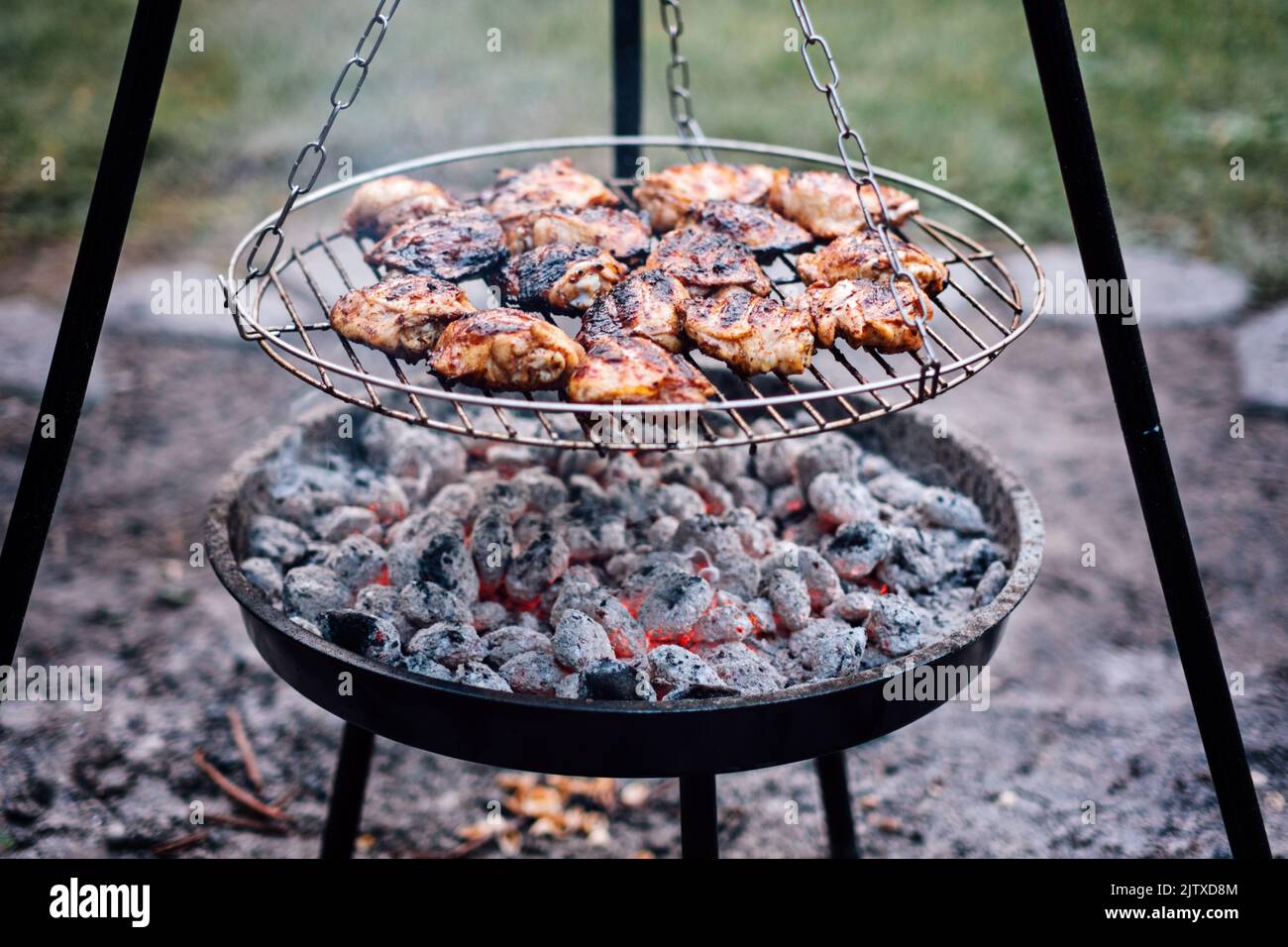Cosce di pollo alla griglia all'aperto. Pollo alla griglia. Frillare le cosce e le cosce di pollo con osso Foto Stock