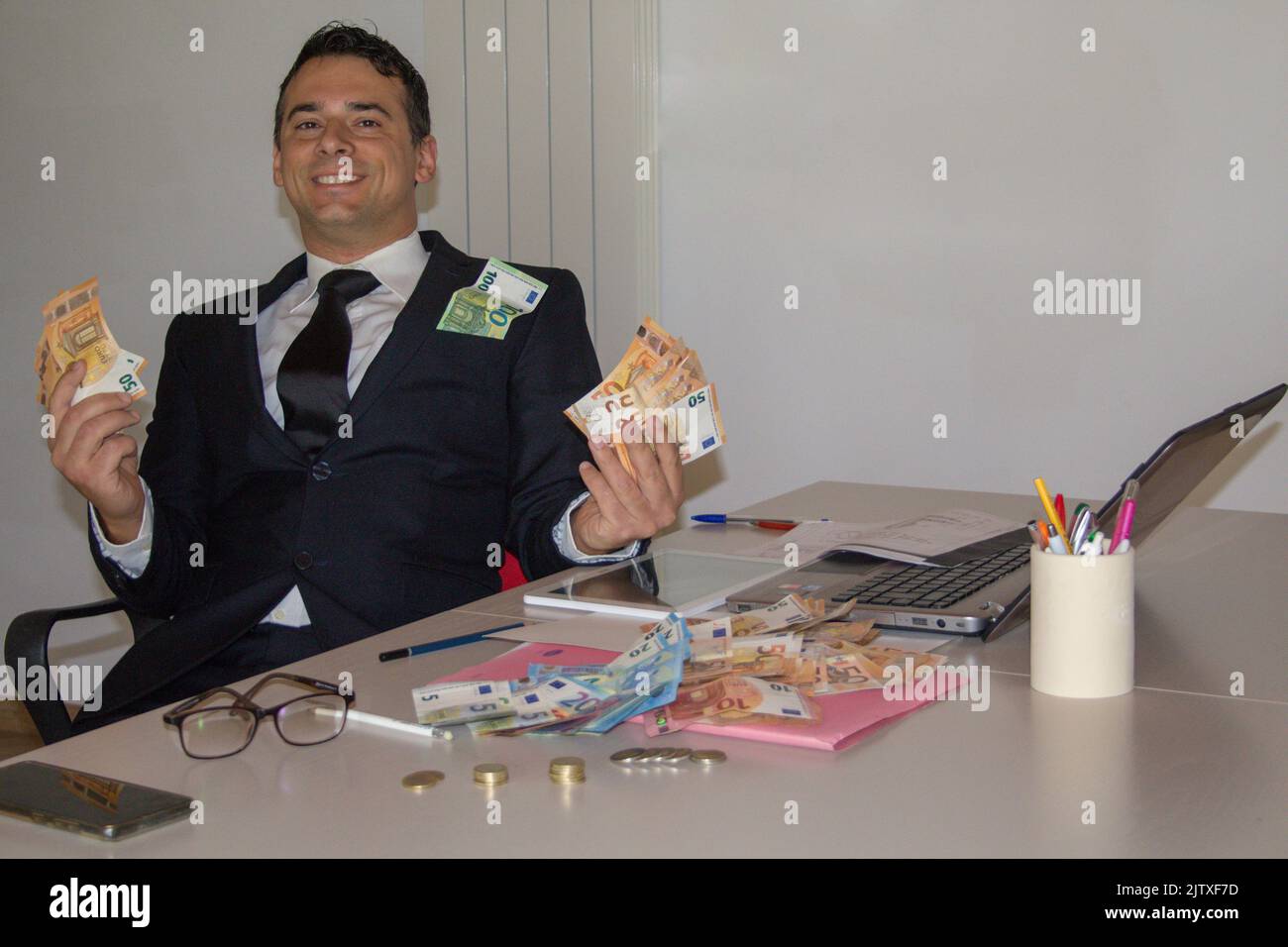 uomo d'affari in carica con banconote in mano che ha fatto fortuna in finanza Foto Stock