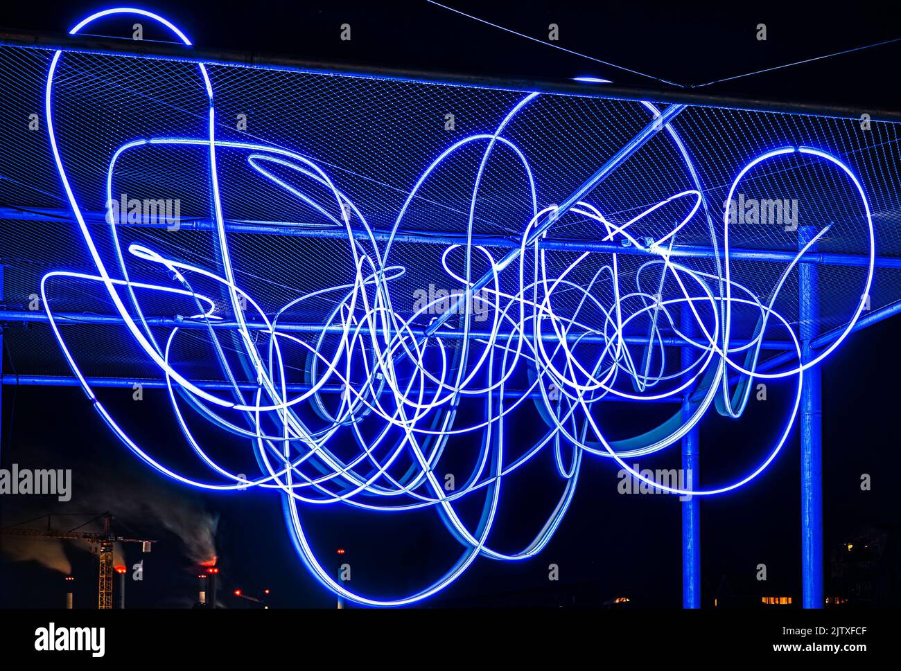 Il modello di spaghetti di fasci di luce sospesi con camini da fumo mostra come le industrie inquinanti producono elettricità e alimentano il progresso digitale Foto Stock