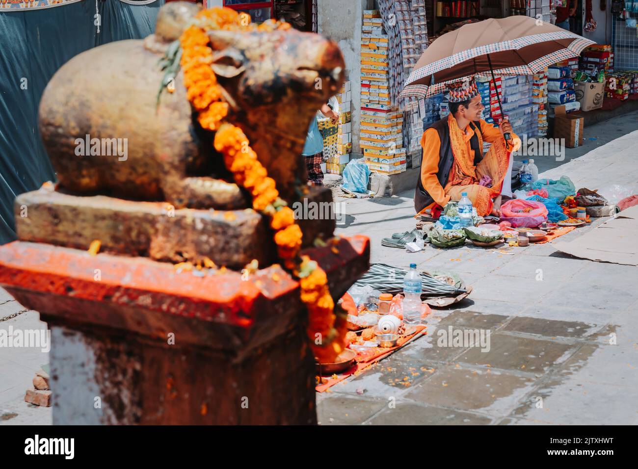 Kathmandu, Nepal - 12 agosto 2022 : Un prete indù che aspetta i visitatori ai locali del tempio durante Janai Purnima o il festival rakshya Bandhan a Kathma Foto Stock