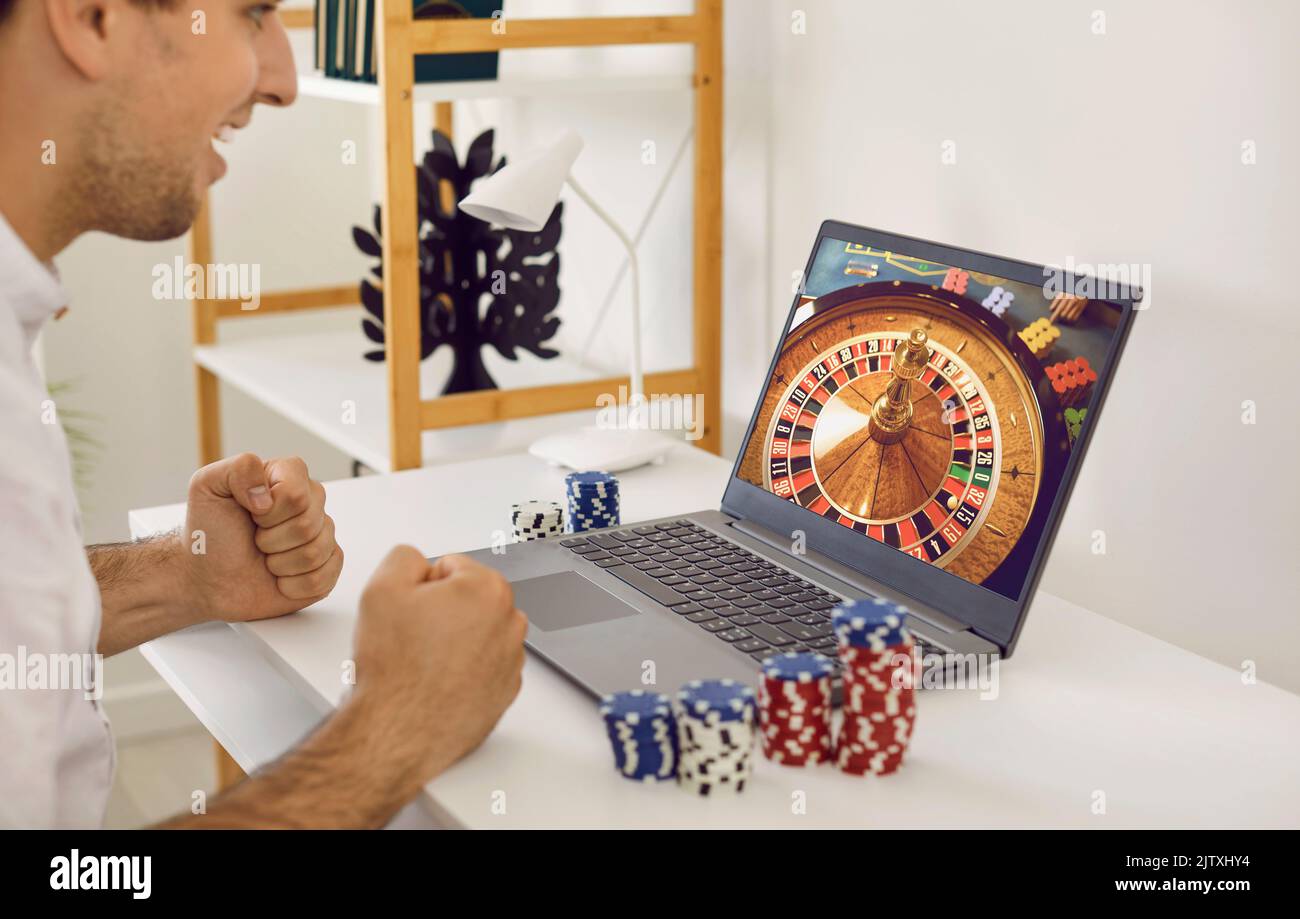 Lucky gambling man vince un sacco di soldi sul sito web del casinò online sul computer portatile Foto Stock