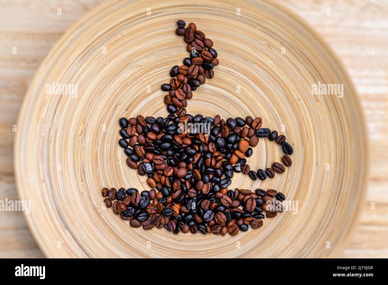 Simbolo di una tazza di caffè fumante con i chicchi di caffè posizionati su uno sfondo di legno Foto Stock