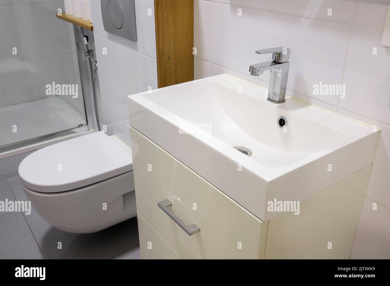 Lavabo bianco con rubinetto e wc ciotola in bagno Foto Stock