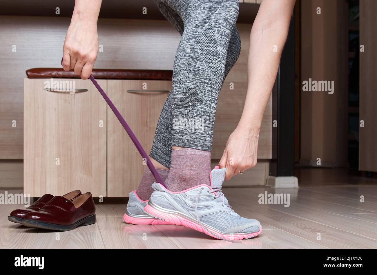 Donna che cambia scarpe prima dell'allenamento. Foto Stock