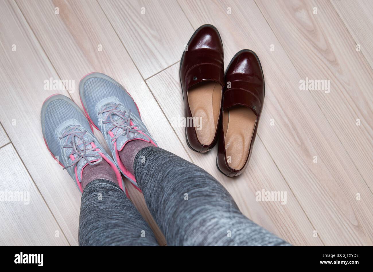 Donna che cambia scarpe prima dell'allenamento. Foto Stock