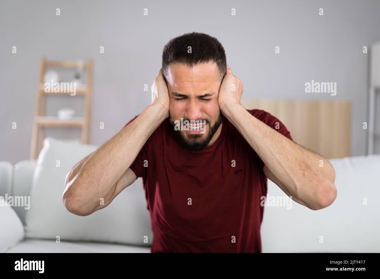 Forte rumore e dolore nell'orecchio dell'uomo Foto Stock