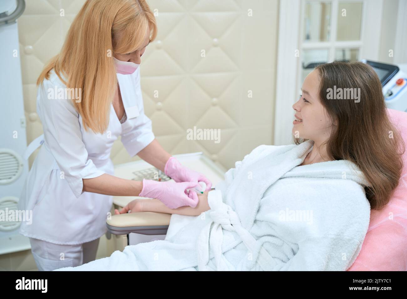 Il medico ha inserito l'ago nella vena del paziente per il prelievo di sangue Foto Stock