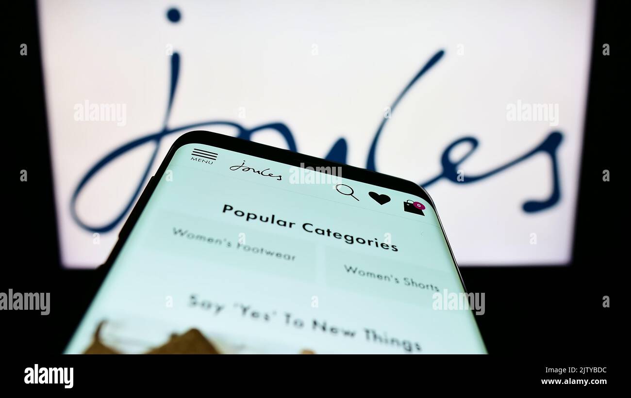 Smartphone con sito Web della società di vendita al dettaglio britannica Joules Group plc sullo schermo di fronte al logo aziendale. Messa a fuoco in alto a sinistra del display del telefono. Foto Stock