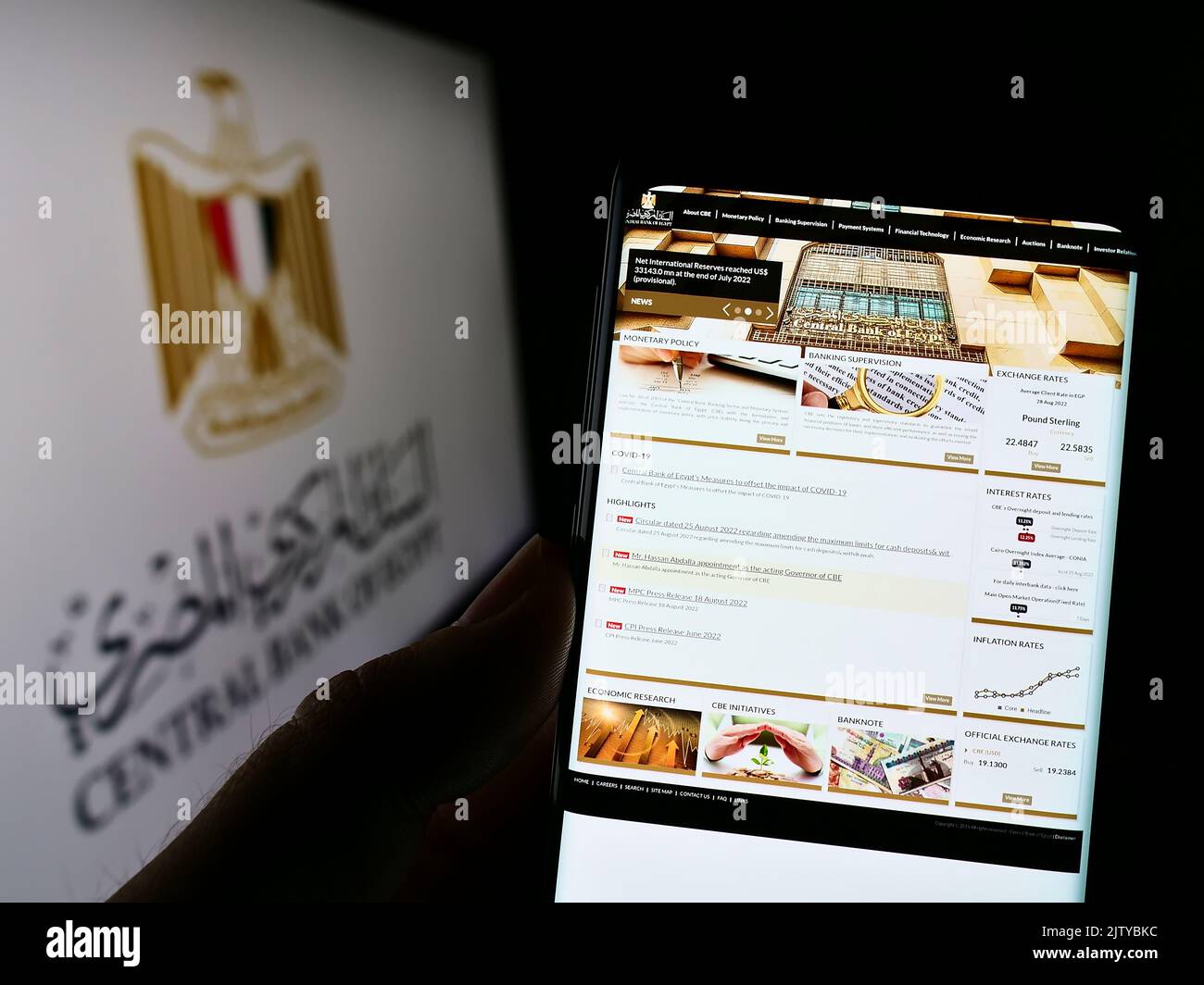 Persona in possesso di smartphone con pagina web dell'autorità monetaria Banca centrale d'Egitto (CBE) sullo schermo con logo. Messa a fuoco al centro del display del telefono. Foto Stock