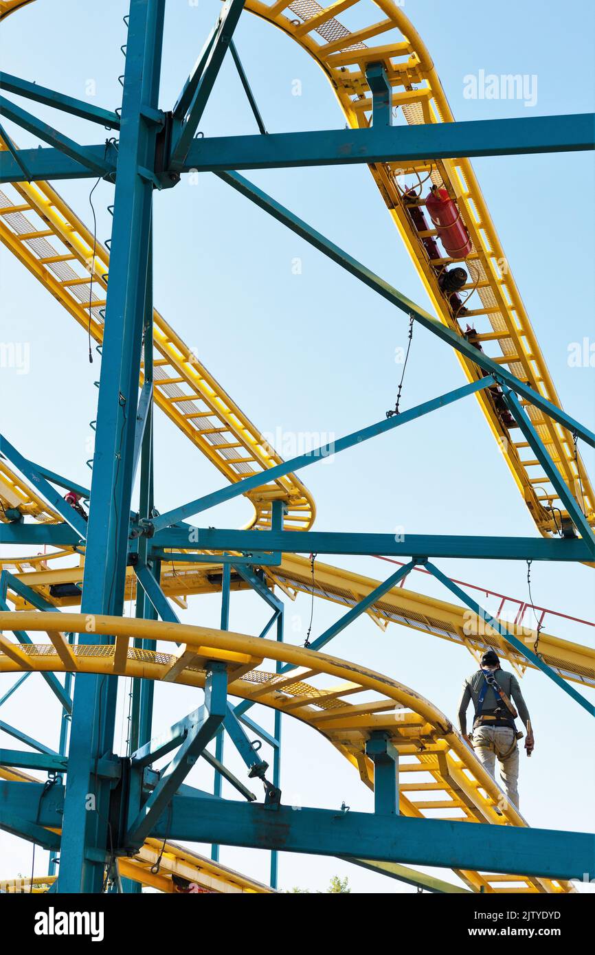 Un addetto alla manutenzione che cammina sulla pista di una montagna russa, alla fiera statale del Minnesota a St. Paul, Minnesota. Foto Stock