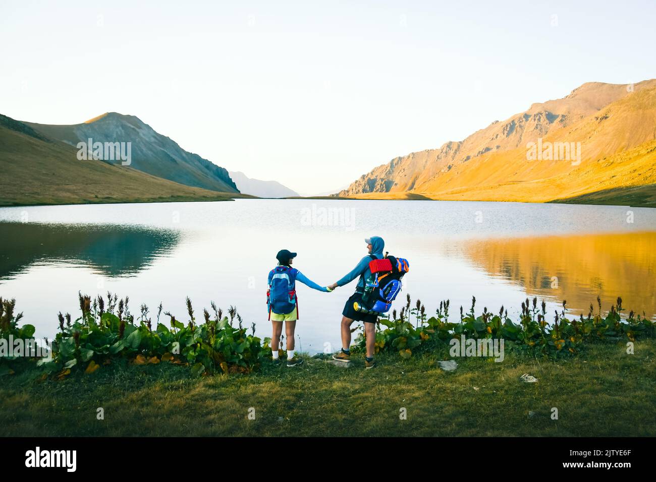 Coppia di escursionisti caucasici stare felici insieme all'aperto da scenico lago di roccia nera in Georgia. Turista godere di vacanze attive nella natura in amore avventura Foto Stock