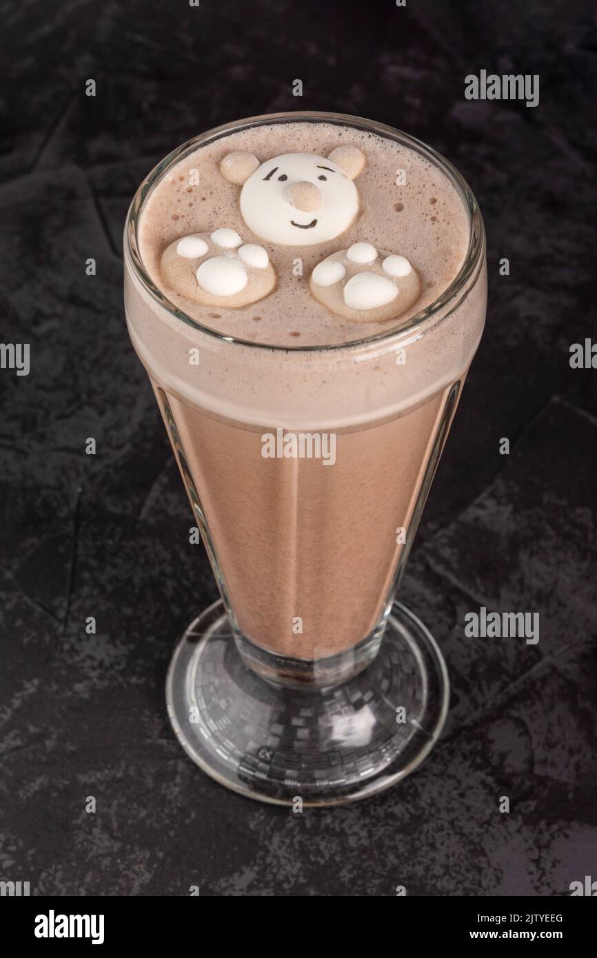 bevanda al cacao decorata con divertenti biscotti su sfondo scuro in una caffetteria Foto Stock