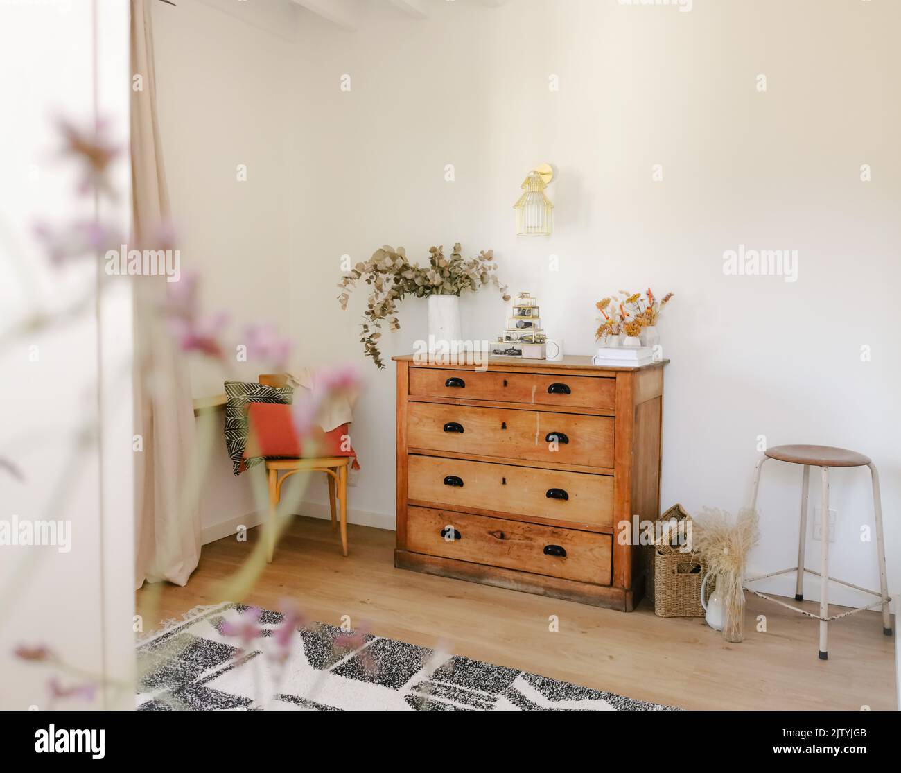 Interni accoglienti in tonalità naturali con mobili in legno antico, soffitti con travi a vista e fiori secchi come eucalipto. Design rustico moderno. Foto Stock