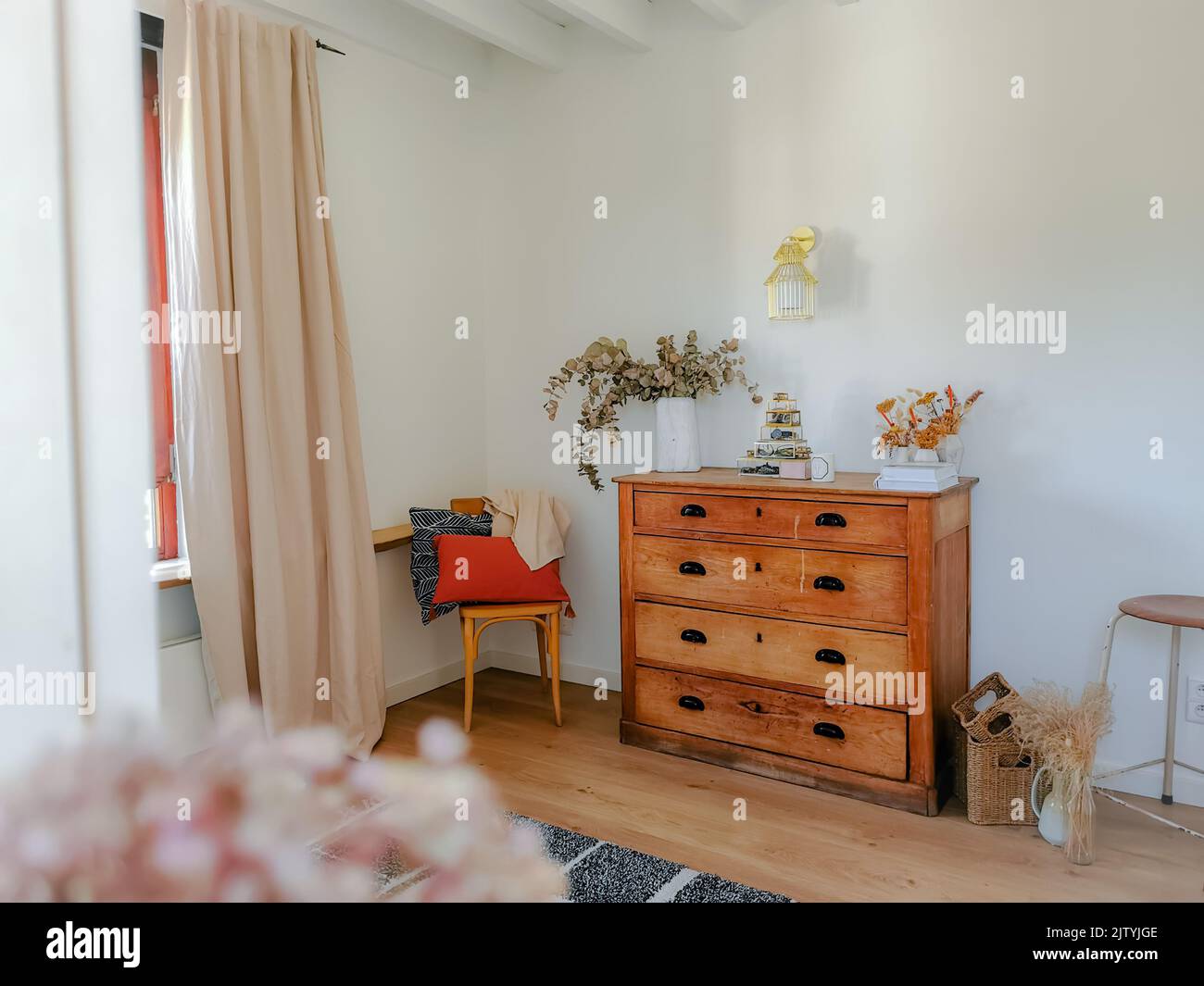 Interni accoglienti in tonalità naturali con mobili in legno antico, soffitti con travi a vista e fiori secchi come eucalipto. Design rustico moderno. Foto Stock