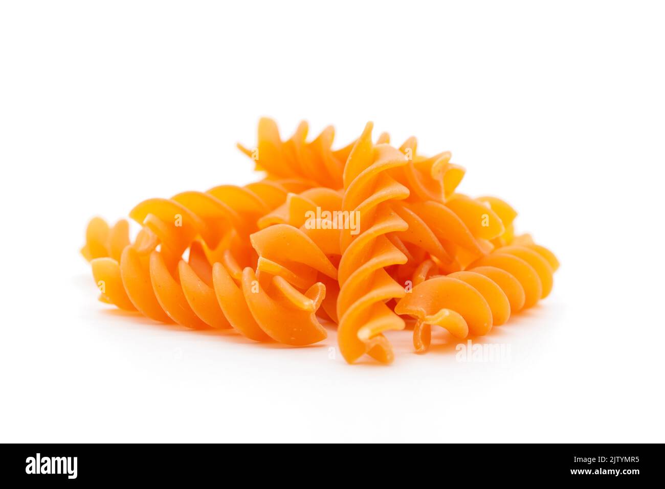 Pasta in primo piano, di colore arancione, vegana, pasta, fusilli, noodle, sfondo bianco, immagine ritagliata Foto Stock