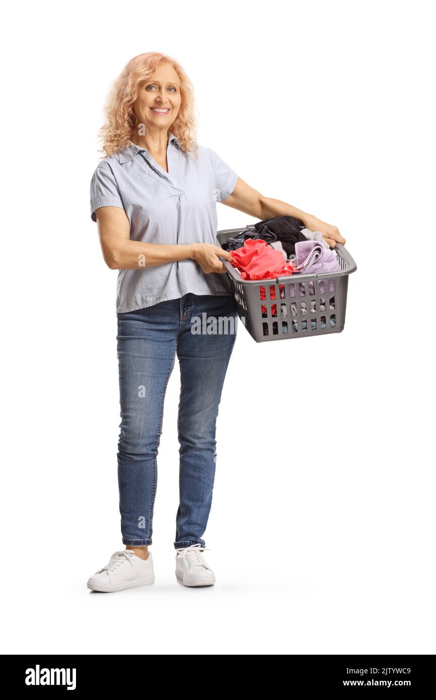 Ritratto a tutta lunghezza di una donna matura che tiene un cesto di bucato con vestiti isolati su sfondo bianco Foto Stock