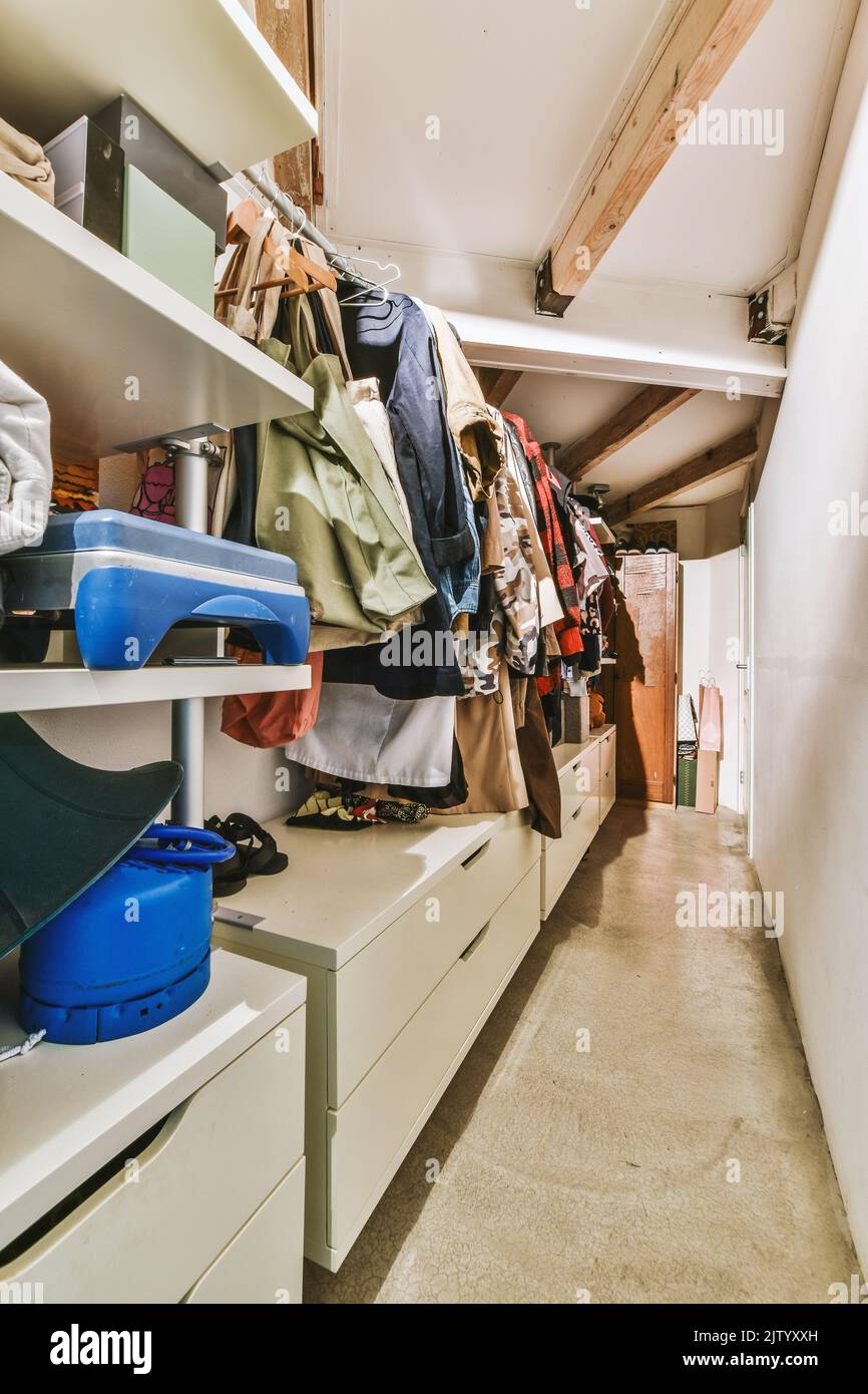guardaroba bianco con specchi vicino alla chitarra e cabinet nella stanza luminosa di casa Foto Stock