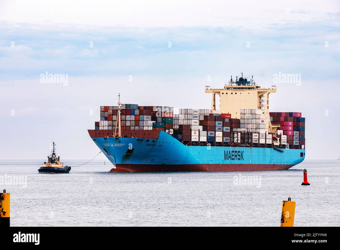 Tug guida la nave portacontainer Maersk Luz fino alla zona di scarico nel porto d'oltremare di Bremerhaven Foto Stock