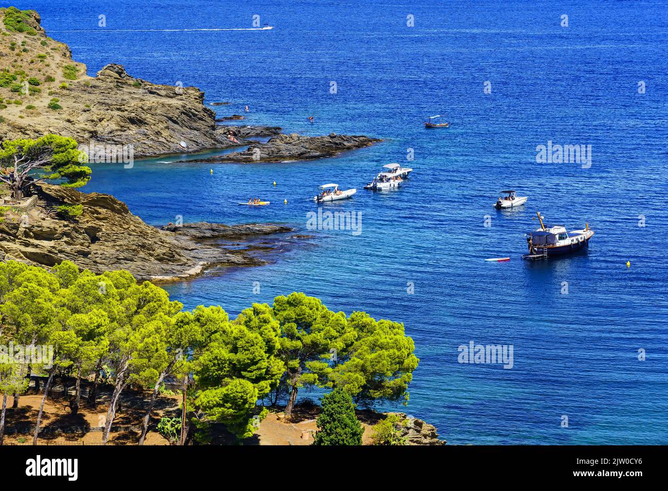 Paesaggio mediterraneo sul mare con pini sulla costa e barche ormeggiate nelle insenature di Girona, Catalogna. Foto Stock