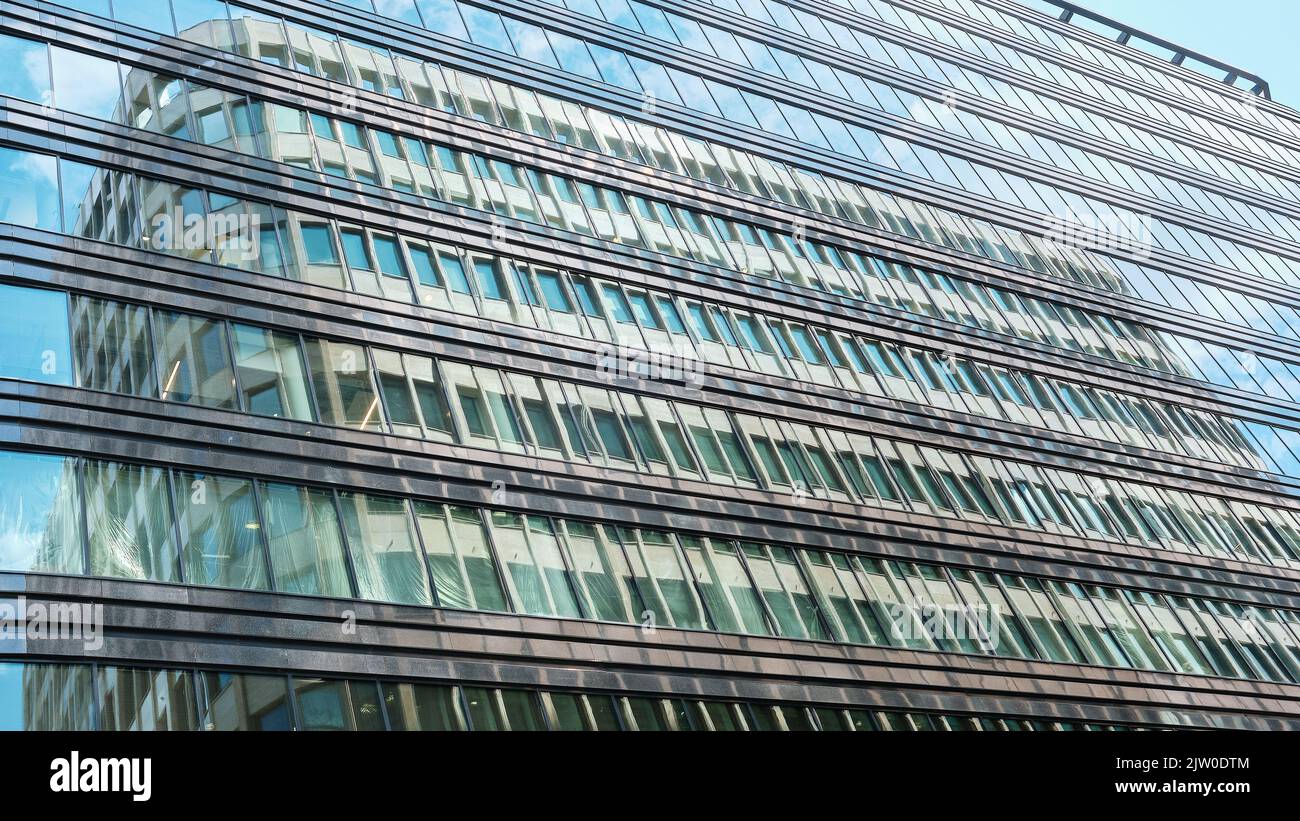 Riflessioni nella lunga fila di finestre del moderno business center White Gardens, vista dal basso: Mosca, Russia - 22 luglio 2022 Foto Stock