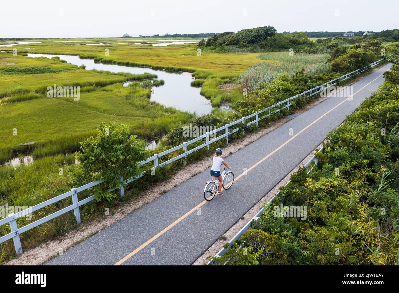 Drone aereo di Woman bike attraverso Cape Cod Marshes pista ciclabile Foto Stock