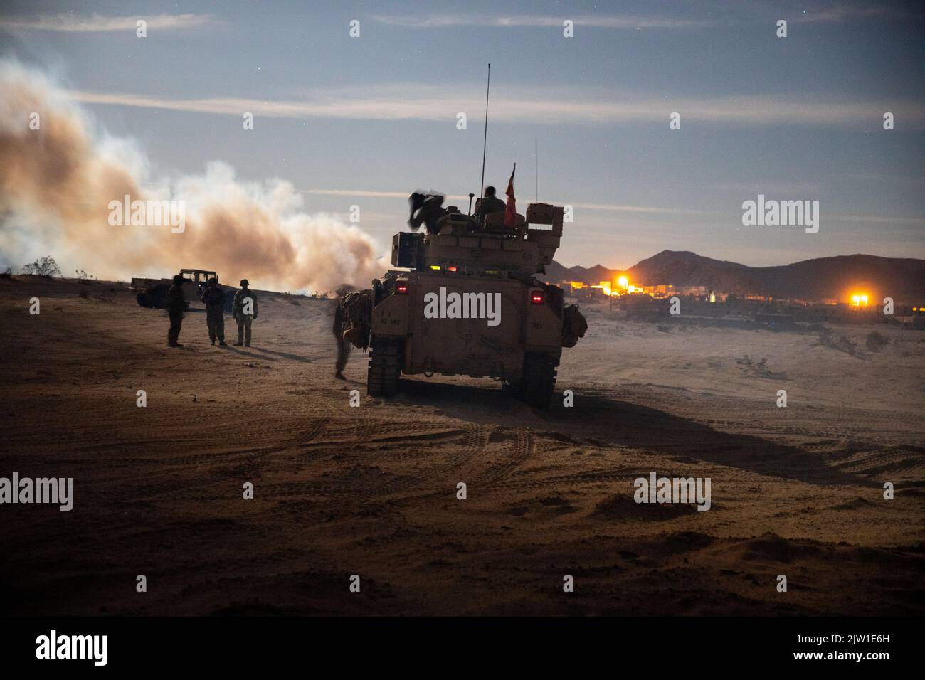 Un veicolo da combattimento Bradley assegnato al 1st Combined Arms Battalion, 63rd Armor Regiment, 2nd Armored Brigade Combat Team, 1st Infantry Division si prepara ad allevare le difese di un checkpoint durante un allenamento presso il National Training Center di Fort Irwin, California, 11 agosto 2022. Il Bradley fu incaricato di spianare la strada ai soldati di terra per iniziare l'assalto a una città fittizia. (STATI UNITI Esercito foto di PFC. Kenneth Barnet) Foto Stock