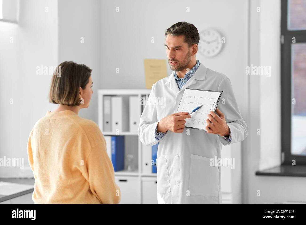 medico che mostra il cardiogramma a una donna in ospedale Foto Stock