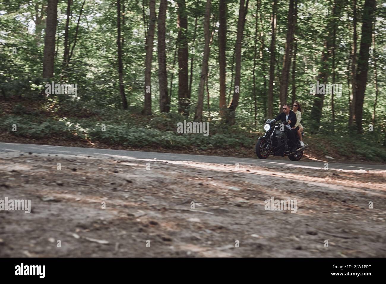 Movimento blurred giovane coppia su una moto nessun casco giro sulla strada ad alta velocità, guida pericolosa, in movimento Foto Stock