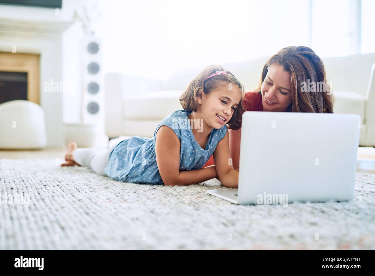 Uso della tecnologia per educare e intrattenere. Una madre e una figlia che usano un notebook insieme a casa. Foto Stock