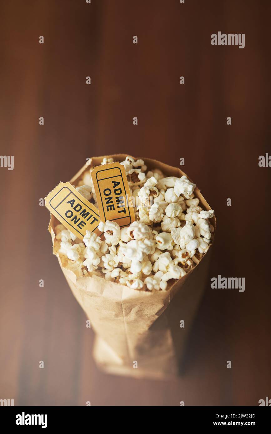 I film si sono arent lo stesso senza popcorn. Un sacchetto di popcorn e due biglietti per il film su uno sfondo di legno. Foto Stock