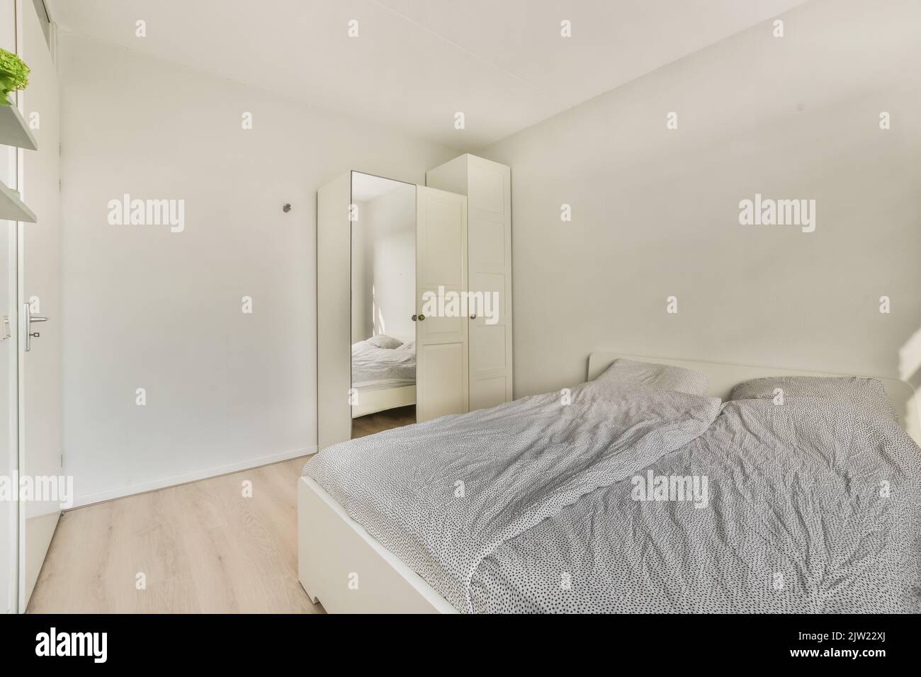 Comodo letto e armadio situato in camera da letto contemporanea a casa Foto Stock