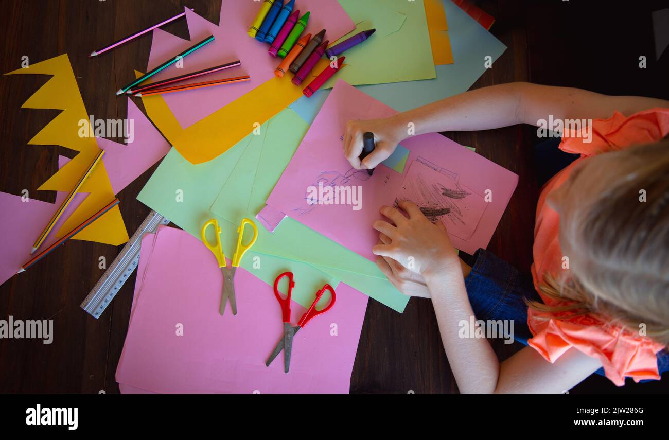 Giovane ragazza disegno su carte colorate Foto Stock